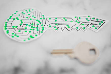 encryption key icon made of circuits and LED lights next to old metal key on white marble background