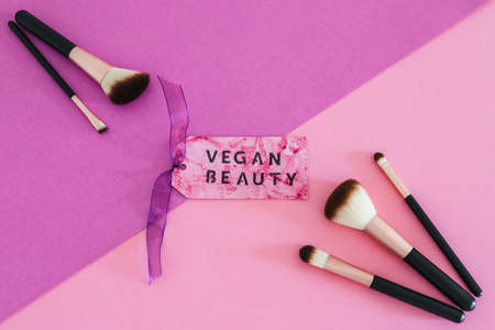 cruelty free beauty products concept, Vegan Beauty message on label next to set of make-up brushesの写真素材