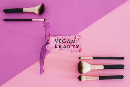 cruelty free beauty products concept, Vegan Beauty message on label next to set of make-up brushesの写真素材