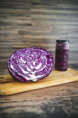 purple cabbage cut in half next to jar of homemade sauerkraut, concept of natural healthy ingredientsの写真素材