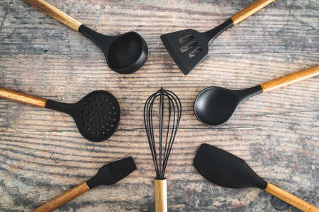 set of matching wooden and silicone kitchen utensils, concept of cooking meals at home or learning to cookの写真素材