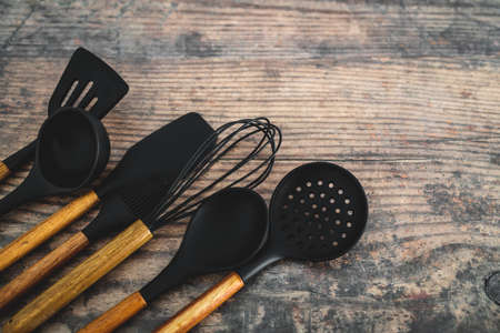 set of matching wooden and silicone kitchen utensils, concept of cooking meals at home or learning to cookの写真素材