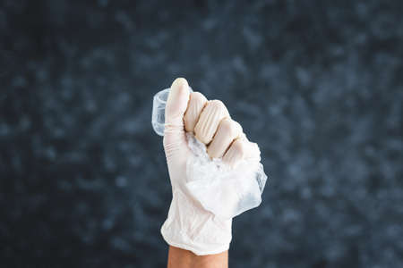 hand with glove picking up single-use plastic bag to be recycled, concept of cleaning the environment and fighting wasteの写真素材