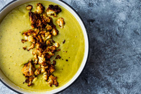 vegan homemade creamy broccoli soup with roasted cauliflower topping, healthy plant-based food recipesの写真素材