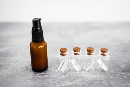 amber skincare bottle with small bottles of ingredients inext to it, concept of natural beauty and organic ingredients in skincareの写真素材