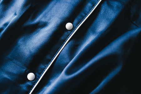 luxurious navy blue silk or satin tailored pyjama detail, fabric close-up with soft wrinkles and light shining on itの写真素材