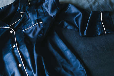 luxurious navy blue silk or satin tailored pyjama detail, fabric close-up with soft wrinkles and light shining on itの写真素材