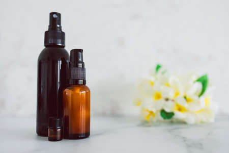 natural beauty and organic ingredients in skincare, apothecary skincare bottles with tropical frangipani flowers in the backgroundの写真素材