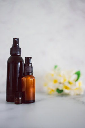 natural beauty and organic ingredients in skincare, apothecary skincare bottles with tropical frangipani flowers in the backgroundの写真素材