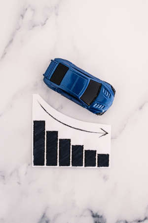 car loans rentals and car prices increasing, blue toy car next to graph showing stats going up...