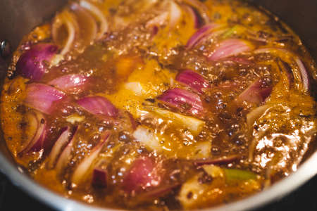 vegan turkish gÃ¼veÃ§ hot pot with eggplant celeri and potaotes in spicy broth with mixed herbs cooking on the stove, healthy plant-based food recipesの写真素材