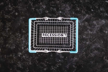 recession and stagnating economy conceptual image with text inside of shopping basketの写真素材