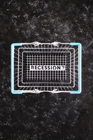 recession and stagnating economy conceptual image with text inside of shopping basketの写真素材