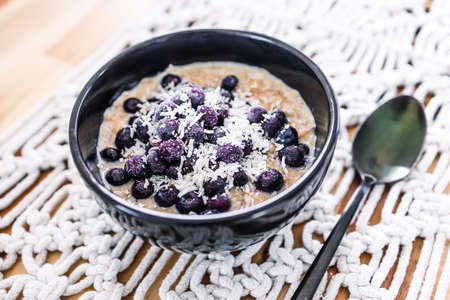 vegan oatmeal porridge with blueberries and coconut, healthy plant-based food recipesの写真素材