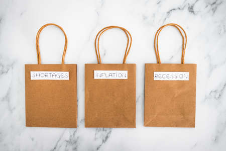 economy conceptual image, inflation shortages and recession texts on shopping bags,