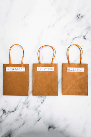 economy conceptual image, inflation shortages and recession texts on shopping bagsの写真素材