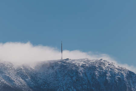 Snow on the mountain tops with clouds rolling over the pinnacles shot in Tasmania, Australiaの写真素材