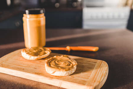 peanut butter on freshly toasted English muffins for breakfast with kitchen bokeh, healthy vegan food recipesの写真素材