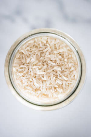 glass jar with jasmine rice close-up shot from top down perspective, healthy pantry ingredients and staplesの写真素材