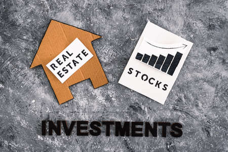 investment opportunities and building wealth conceptual image, house icon next to stock market stats with text underneathの写真素材
