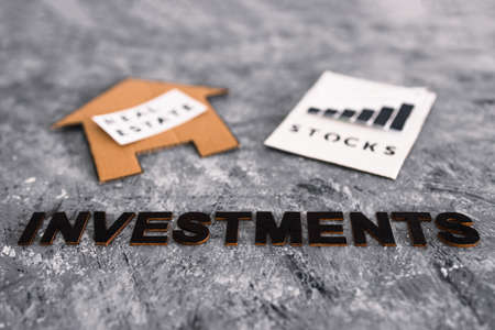 investment opportunities and building wealth conceptual image, house icon next to stock market stats with text underneathの写真素材