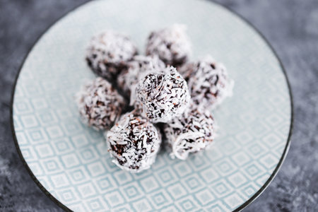 plant-based chocolate and nut butter bliss balls with coconut topping, healthy vegan food recipes