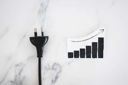 electricity costs going up ,conceptual image with plug nxt to stats graph showing prices going upの写真素材