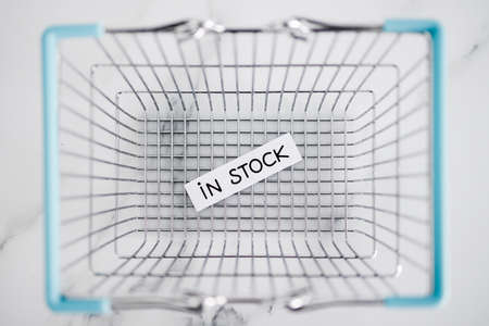 In stock text inside of shopping basket, concept of shopping and retail