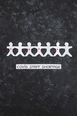 staff shortages and business struggling after the pandemic conceptual image, paper people chain with...