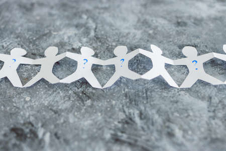 staff shortages and business struggling after the pandemic conceptual image, paper people chain with question marks on some workers and Short-staffed text on black backgroundの写真素材