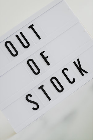 Out of stock text on lightbox on minimalistic white marble background, concept of supply chain shortages and delays after the covid-19 global pandemicの写真素材