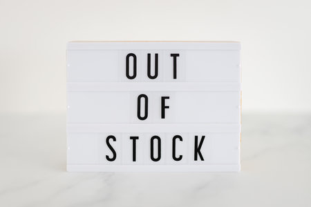Out of stock text on lightbox on minimalistic white marble background, concept of supply chain shortages and delays after the covid-19 global pandemicの写真素材