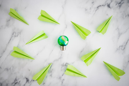 green economy and innovation for the environment conceptual image, green light bulb idea next green paper planes metaphor of new ideas and inventionsの写真素材