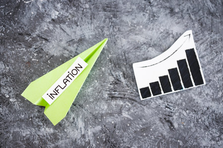 inflation text on paper planes going up with stats graph next to it, concept of economic struggles after the pandemicの写真素材