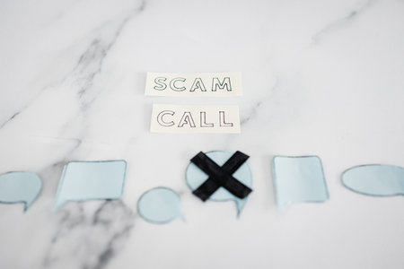 scam calls and personal data theft concept, text with comic bubbles with one of them crossed out on marble backgroundの写真素材