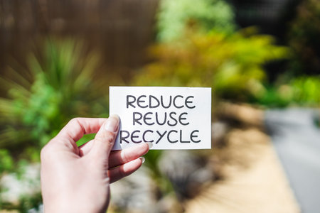 reduce reuse recycle sign in front of backyard bokeh, concept of sustainability and circular economyの写真素材