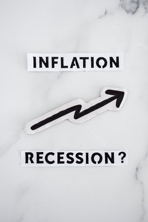 inflation with arrow going up and recession texts with question mark underneath, concept of economic issues after the pandemicの写真素材