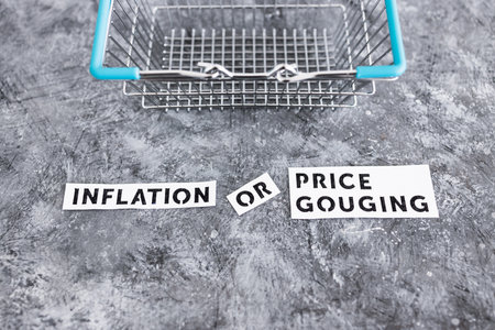 inflation or price gouging text with shopping basket representing prices going up, concept of...