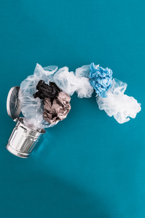 recycling and avoiding landfill conceptual image, open trash can with single use plastic bags  and paper flying into ot out of itの写真素材