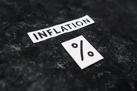 Inflation text with percentage symbol on dark background, concept of economic struggles after the...