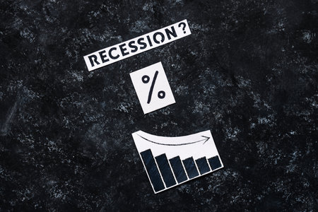 Recession? text with percentage symbol and chart with economic growth going down on dark background, concept of post pandemic economy and cost of livingの写真素材