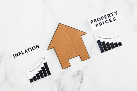 graphs with inflation going up and property prices going down next to cardboard house, concept of post pandemic economy during winter 2022の写真素材