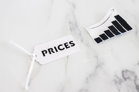 Prices text on product tag next to graph with stats going up, concept of inflation and price hikesの写真素材