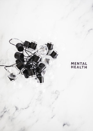 mental health text next to groupd of tangled up light bulbs, psychology concept