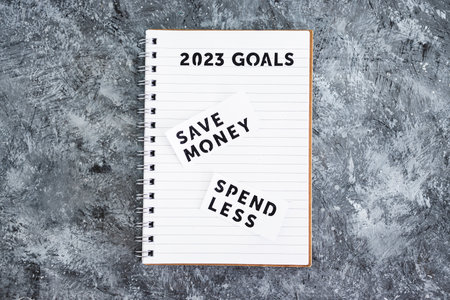 save money and spend less on 2023 goals notebook, concept of financial stability and being free from...