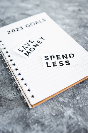 save money and spend less on 2023 goals notebook, concept of financial stability and being free from...