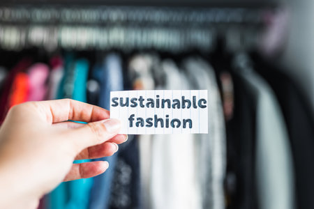 Sustainable Fashion held in front of wardrobe full of clothes, concept of ethical practices in the fashion industryの写真素材