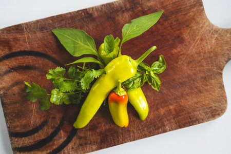 fresh chili peppers and herbs on rustic wooden cutting board, concept of simple natural healthy ingredientsの写真素材