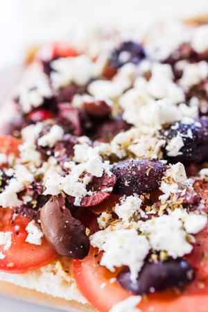 focaccia with fresh tomatoes kalamata olives and feta sprinkled with herbs, healthy food recipesの写真素材