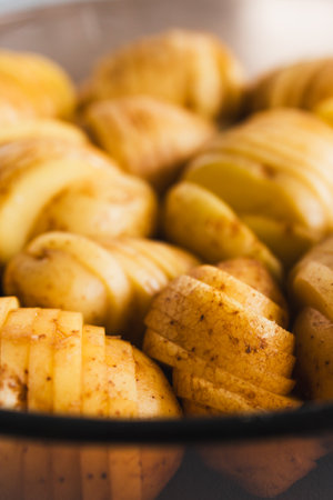 plant-based hasselback potatoes about to go in the oven, healthy vegan food recipesの写真素材